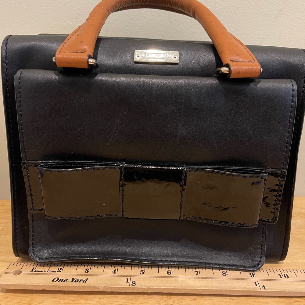 Kate Spade black leather satchel w/patent bow & detach strap. Camel handles.
